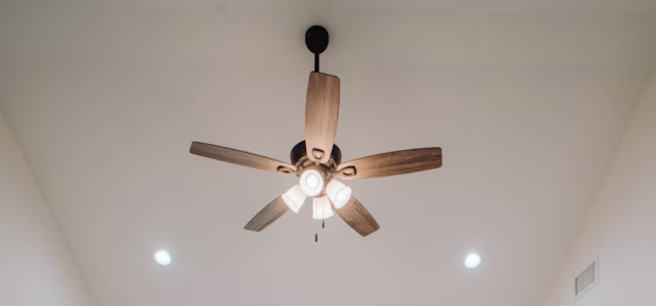 Wooden ceiling fan with light fixture on a white ceiling.